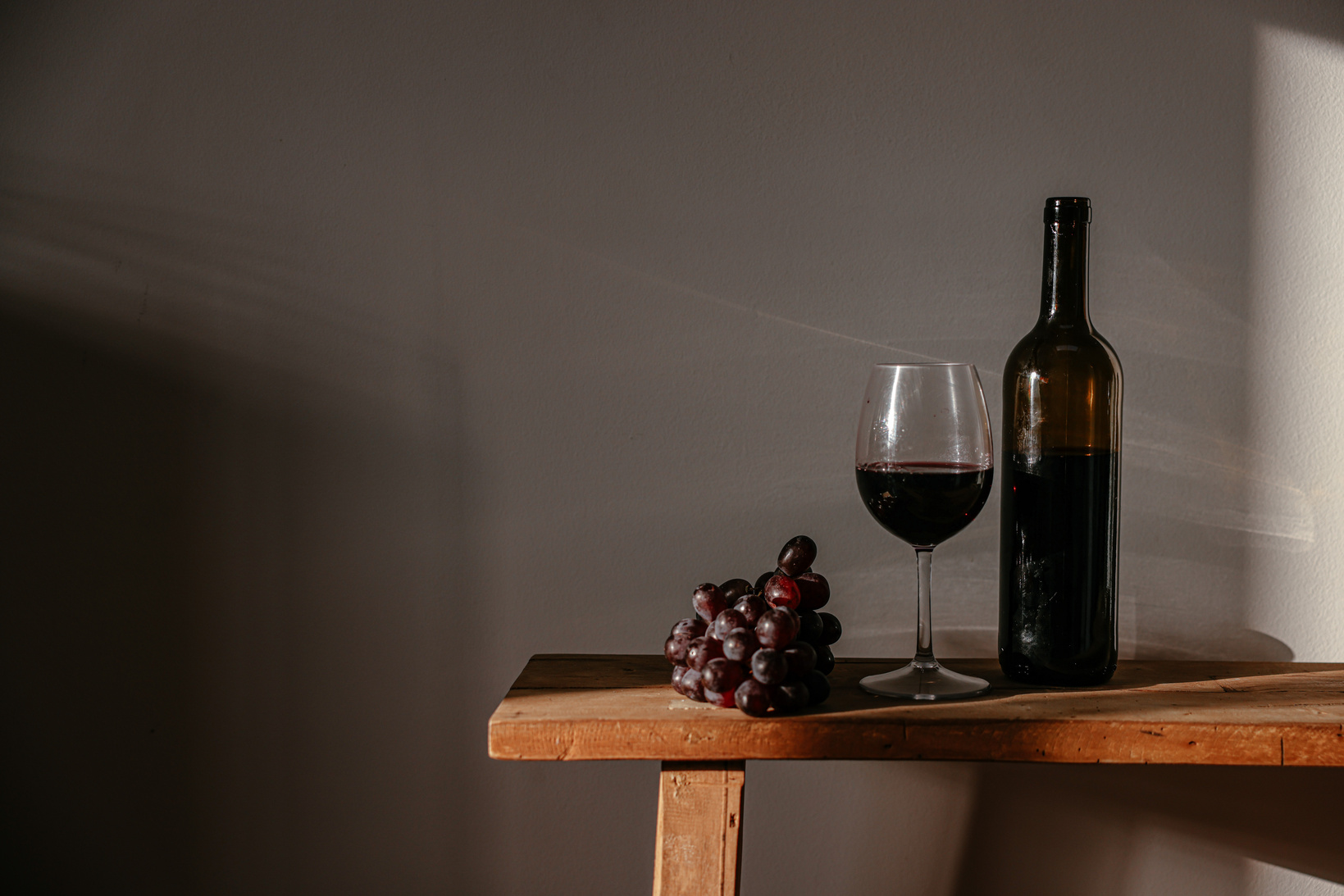  A Bottle and a Glass of Wine on a Wooden Bench